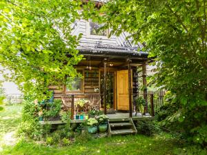 una pequeña casa con un porche con macetas en Dom drewniany Ozwa, en Gronków