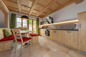 eine Küche mit Holzschränken sowie einem Tisch und Stühlen in der Unterkunft Neuerbaute Ferienhaushälfte 4erspitzblick in Mittenwald