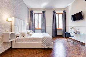 a bedroom with a bed and a desk and a tv at Trevi Private Suites by Premium Suites Collection in Rome