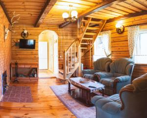 a living room with couches and a fireplace in a cabin at Ignalina Lux Villa in Ignalina