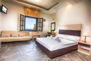 a bedroom with a large bed and a couch at Castro Sunset Stories in Neos Marmaras