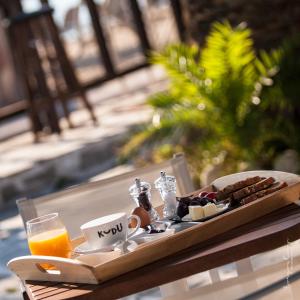 a tray of food on a table with orange juice at Castro Sunset Stories in Neos Marmaras