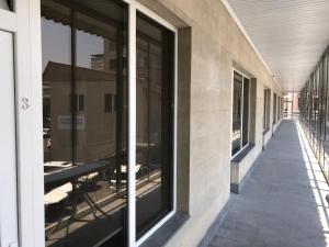 Liko Hostel في يريفان: شرفة فارغة مع طاولات ونوافذ على مبنى