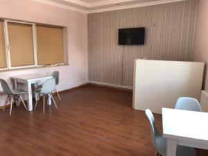 a room with a table and chairs and a tv at Liko Hostel in Yerevan