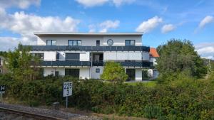 a large white building with a clock on it at Strandstraße H3W6 Kölpinsee in Loddin