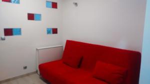a red couch sitting in a room with colorful pictures on the wall at Apartamento Playa Levante in Benidorm