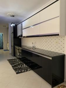 a kitchen with a sink and white cabinets at Marinela Apartment in Sarandë