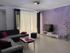 a living room with a couch and a tv at Marinela Apartment in Sarandë