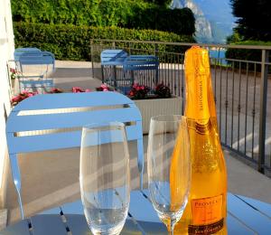 a bottle of champagne and two glasses on a table at B&B I LAKE IT BELLAGIO in Bellagio