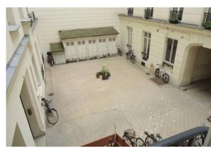 une cour avec des vélos garés devant un bâtiment dans l'établissement En plein cœur de St germain dès Prés, à Paris