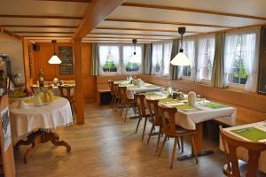 ein Esszimmer mit Tischen und Stühlen und Fenstern in der Unterkunft Gasthaus Sternen in Degersheim