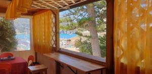 - une fenêtre dans une chambre avec vue sur l'eau dans l'établissement Hotel Giardino delle Palme, à Campese