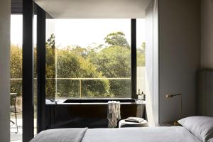 a bedroom with a bed and a large window at United Places Hotel Botanic Gardens in Melbourne +18 photos