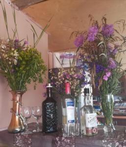 un tavolo con bottiglie di vino, bicchieri e fiori di Levan & Megi a Jut'a