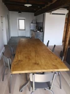einen großen Holztisch in einem Zimmer mit Stühlen in der Unterkunft Cottage AU TERMINUS 2 climatisé in Hautvillers