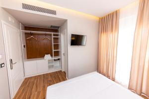 a bedroom with a bed and a tv in it at Inada Hotel Ksamil in Ksamil