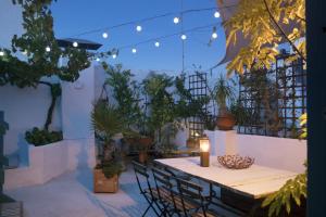 une terrasse avec une table, des chaises et des plantes dans l'établissement amazing Penthouse Cadiz, à Cadix