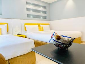 a hotel room with two beds and a table at Hotel City Empire in New Delhi