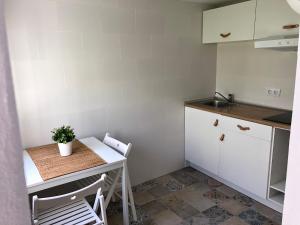 a small kitchen with a small table and chairs at CH Apartments in Conil de la Frontera