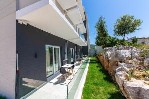 a building with a row of chairs next to a wall at Inada Hotel Ksamil in Ksamil