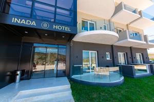 a hotel with a table and chairs outside of it at Inada Hotel Ksamil in Ksamil