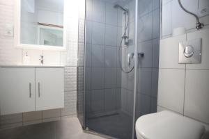 a bathroom with a shower with a toilet and a sink at Apartament wygodny S3 in Kalisz