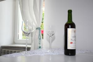 una botella de vino junto a dos copas de vino en Apartament wygodny S3 en Kalisz