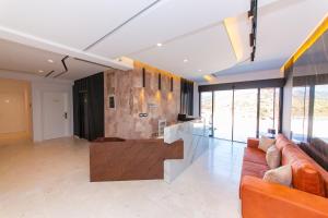 a large living room with orange furniture and glass walls at Inada Hotel Ksamil in Ksamil