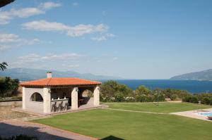 a gazebo on a lawn with a view of the water at Villa Anna in Nafpaktos