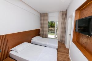 a small room with two beds and a flat screen tv at Inada Hotel Ksamil in Ksamil