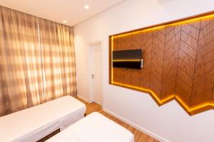 a room with two beds and a wooden wall at Inada Hotel Ksamil in Ksamil