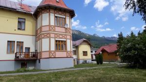 a building with a tower on the side of it at Apartmán Pavilón D-PETER in Vysoke Tatry - Novy Smokovec