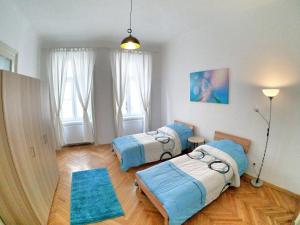 Zimmer mit 3 Betten und blauem Teppich in der Unterkunft Centrally-Located authentic apartment in Wien