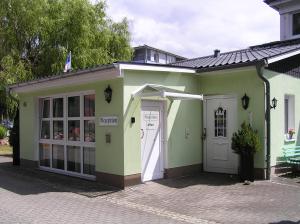 a small green and white building with a door at Pension Dünenhaus in Zempin +16 photos