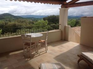 un balcone con tavolo e sedie e vista di Le Mas de l'Escaillon a Saint-Saturnin-lès-Apt