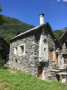 una vieja casa de piedra sentada en la cima de una colina en Rustico Ca d'Damunt, en Cevio