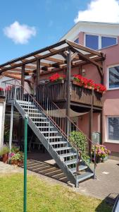 a house with a staircase with flowers on it at Appartmenthaus Gingst in Gingst