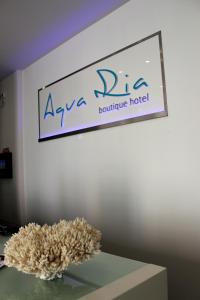 a sign on a wall with a plant on a table at Aqua Ria Boutique Hotel in Faro