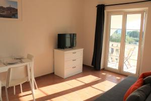 a living room with a tv on a dresser with a table at Villa Kiki in Rovinj