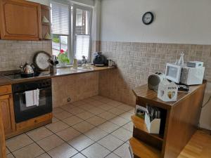 una cucina con lavandino e bancone con forno a microonde di Ferienwohnung Menden a Menden