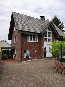 una casa in mattoni rossi con un garage bianco di Ferienwohnung Menden a Menden