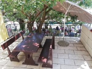 un tavolo da picnic e un ombrellone su un patio di Apartman Marina a Krvavica