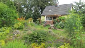 a garden in front of a house with flowers at Idylle in ländlicher Umgebung in Weitenhagen
