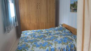 a bedroom with a bed with a blue floral comforter at Idylle in ländlicher Umgebung in Weitenhagen