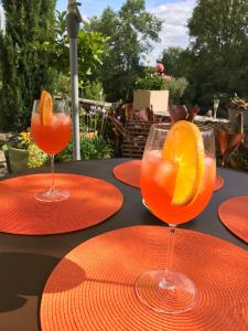 ネラックにあるMoulin de Bapaumesのテーブルの上に並ぶ赤皿のオレンジジュース2杯