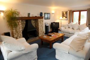 sala de estar con sofás blancos y chimenea en Two Hoots Bed and Breakfast, en Brackley