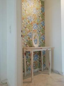 uma mesa num quarto com uma parede floral em SUN AND SEA COTTAGE em Tinos