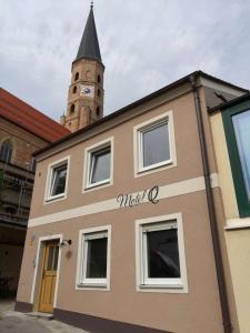 a building with a clock tower in the background at Motel Q - das kleine Stadthotel in Dingolfing