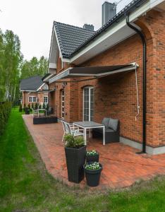 a patio with a table and chairs on a brick building at VILLA AIDO in Palanga