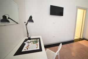 Biały stół z lampą i książką w obiekcie TIFEO Bed & Breakfast w Katanii